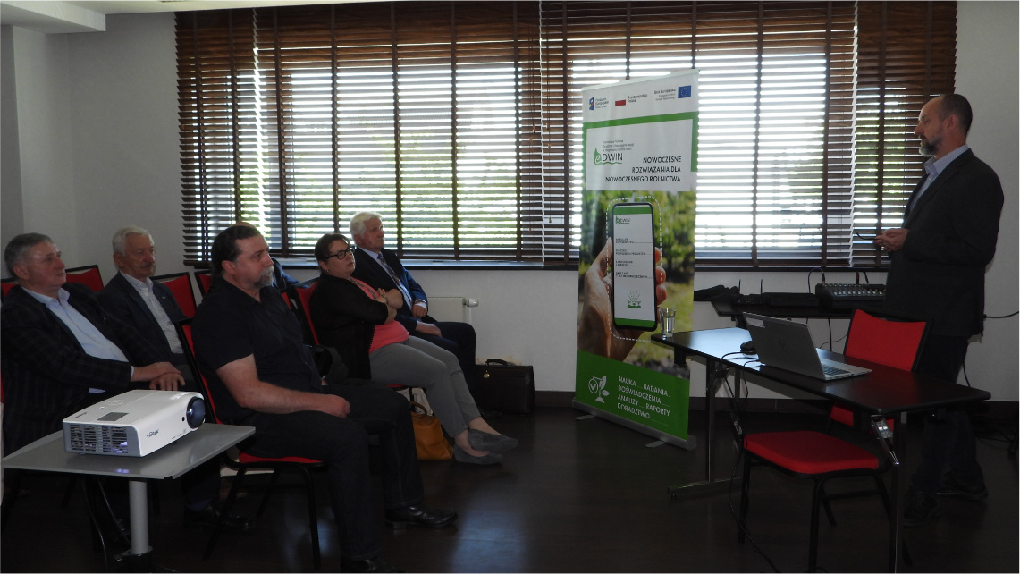 Jeden z wykładów było innowacyjne podejście do wymogów integrowanej ochrony roślin Wnętrze sali konferencyjnej. Młody mężczyzna stoi przodem do słuchaczy i prowadzi wykład. W tle widać okna