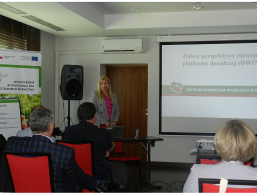 Perspektywy rozwoju eDWIN były jednym z tematów konferencji Wnętrze pomieszczenia. Młoda kobieta stoi obok rzutnika, na którym wyświetlona jest prezentacja i prowadzi wykład. Przed nią widać słuchaczy.