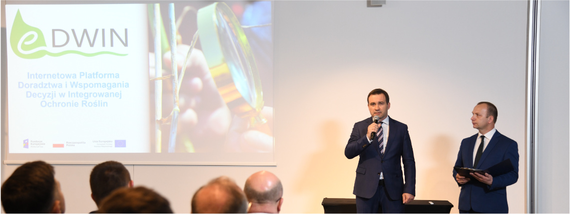 Otwarcia konferencji dokonał Jacek Sommerfeld, dyrektor Wielkopolskiego Ośrodka Doradztwa Rolniczego w Poznaniu Wnętrze sali wykładowej. Dyrektor WODR Jacek Sommerfeld stoi w z mikrofonem w ręku. Obok niego stoi moderator konferencji. Przed mężczyznami widoczni są od tyłu słuchacze konferencji.