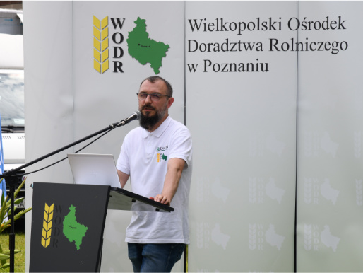 Maciej Zacharczuk, kierownik projektu eDWIN, opowiadał o możliwościach nowej aplikacji Mężczyzna w średnim wieku - Maciej Zacharczuk - stoi i przemawia przez mikrofon przy mównicy. W tle widać logo WODR.
