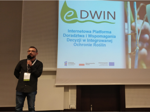 Podczas Forum Inteligentnego Rozwoju Maciej Zacharczuk wygłosił wykład na temat projektu eDWIN Maciej Zacharczuk stoi i wygłasza wykład. W tle telebim, na którym widać logo projektu eDWIN.