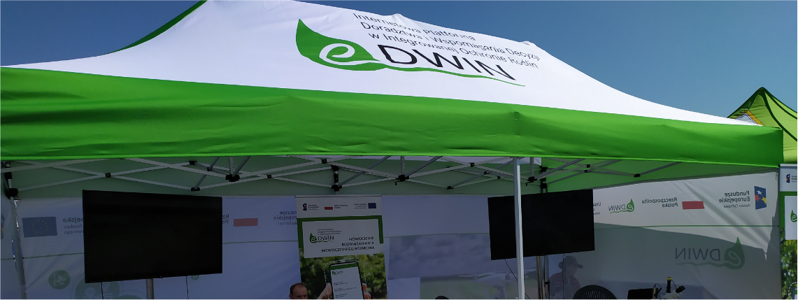Projekt eDWIN był promowany na Krajowych Dniach Pola w Minikowie w 2021 roku Słoneczny dzień. Namiot z logotypem eDWIN na dachu. W środku są telewizory, doradcy rolniczy, krzesła i stoły.